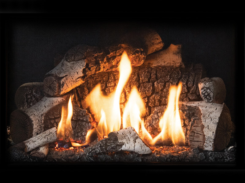 Wood-burning fireplace with tall flames rising over stacked logs and glowing embers, creating a warm, cozy ambiance.