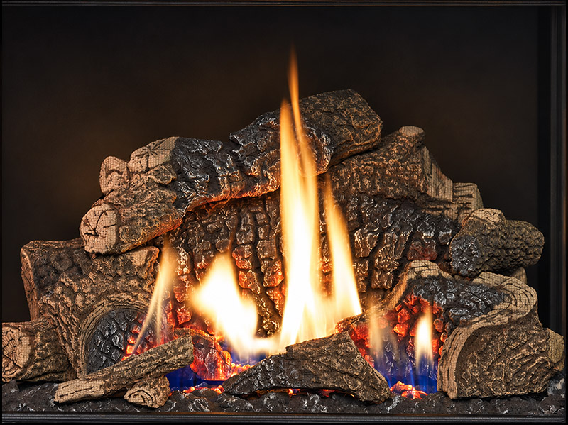 Wood-burning fireplace with glowing embers and tall yellow-orange flames among stacked logs.